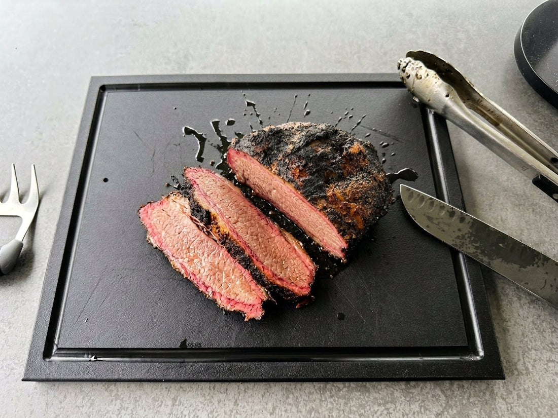 PolySlice black HDPE cutting board with deep juice groove holding smoked meat