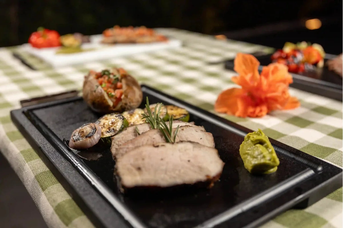 Gourmet presentation of grilled meat and vegetables on a Black PolySlice BBQ Serving HDPE Plate - Professional outdoor dining style.