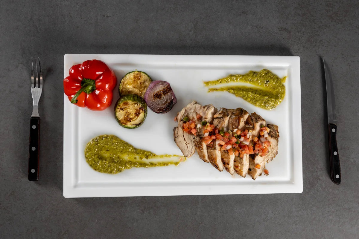 Overhead view of grilled meat and vegetables on a White PolySlice BBQ Plate