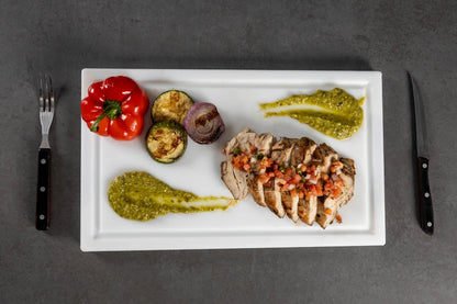 Overhead view of grilled meat and vegetables on a White PolySlice BBQ Plate