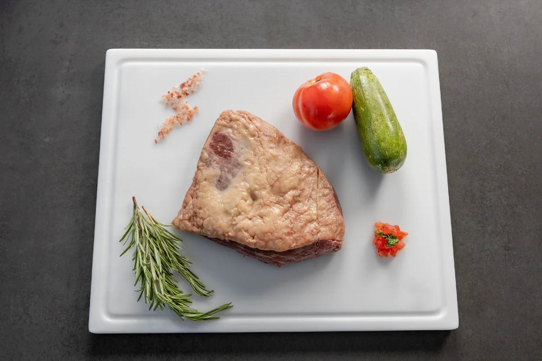 Raw pork belly slices being prepared on a White cutting board