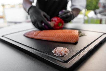 Chef preparing fresh salmon on a sleek Black BBQ board
